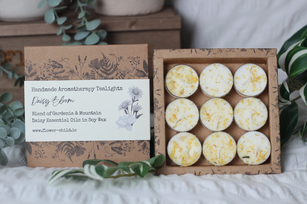 Box of handmade aromatherapy tealights with a branded card on a neutral background