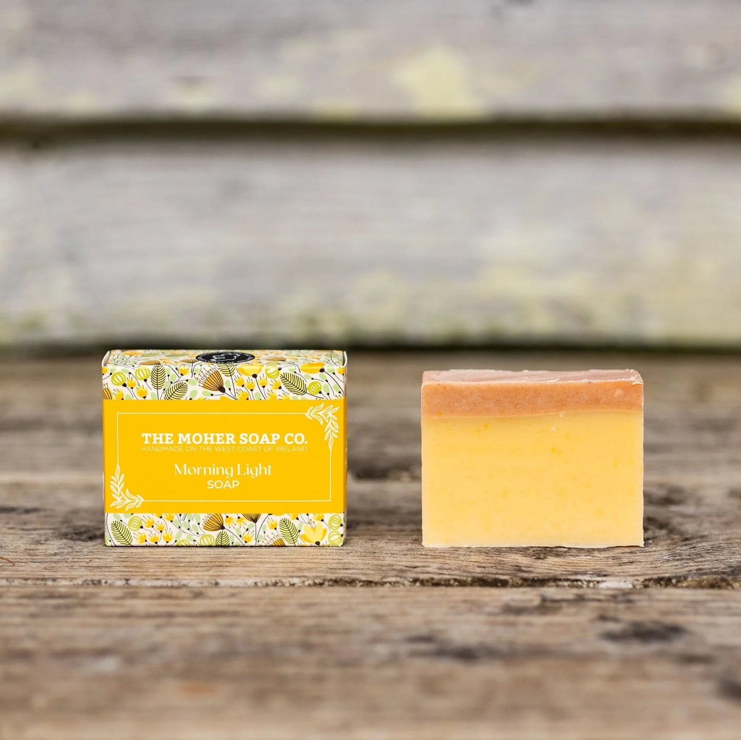 Bar of soap with a yellow packaging label on a wooden surface