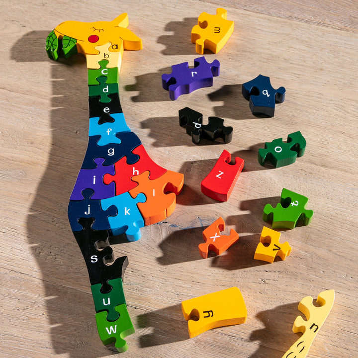 Colorful puzzle pieces shaped like letters on a wooden surface