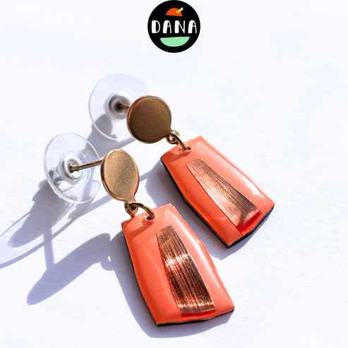Coral earrings with gold accents on a white background, featuring the Dana brand.