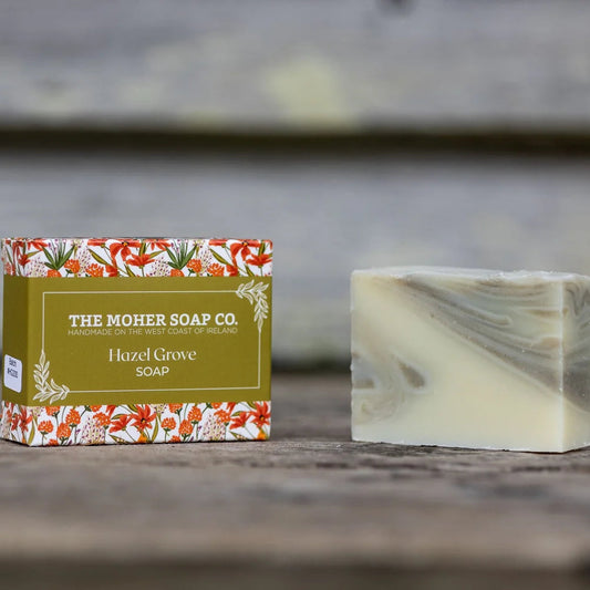 Bar of soap and packaging from The Moher Soap Co. on a wooden surface with a rustic background.