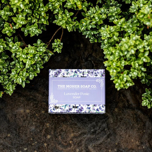 Soap bar from The Mother Soap Co. on a rock with green foliage