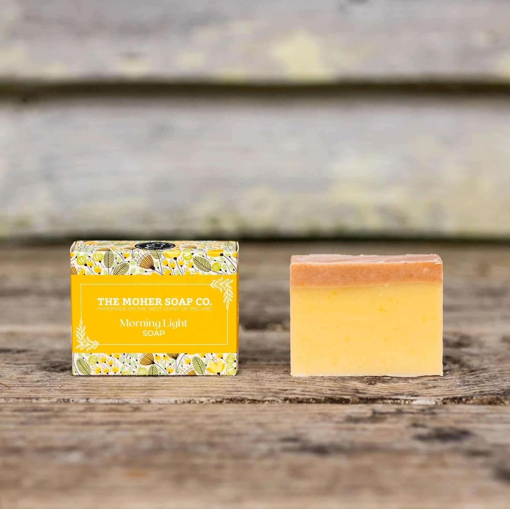 Bar of soap with a yellow packaging label on a wooden surface