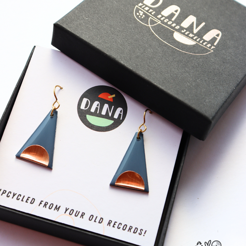 Triangle-shaped earrings in a Dana jewelry box on a white background