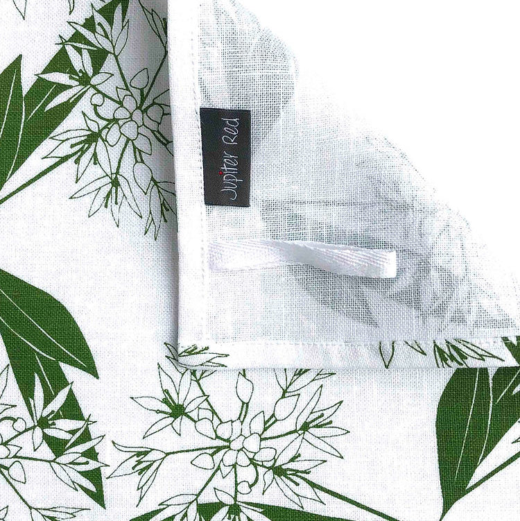 White shirt with green floral pattern and a label on a white background